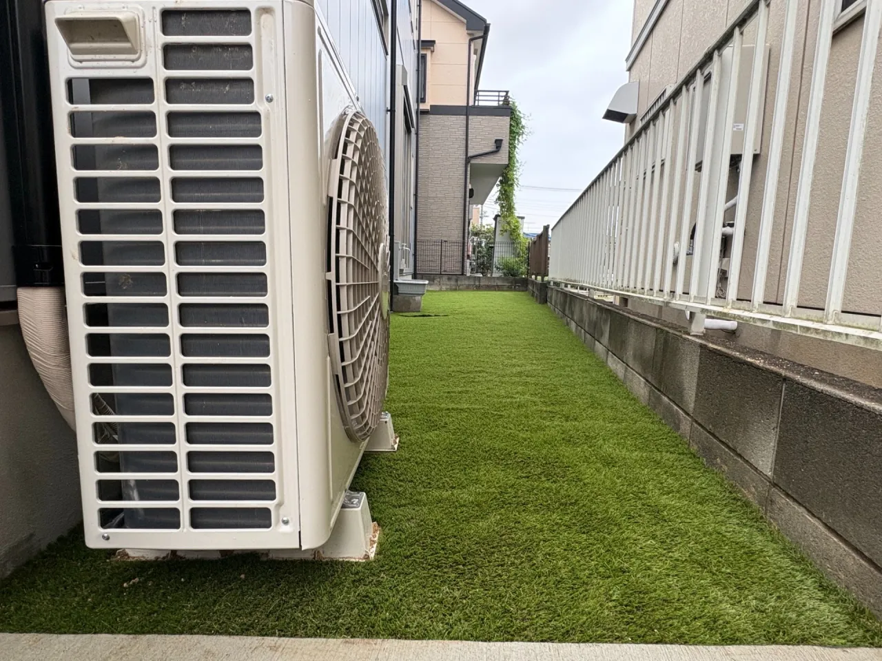 エアコン室外機の下まで人工芝を敷きこみます